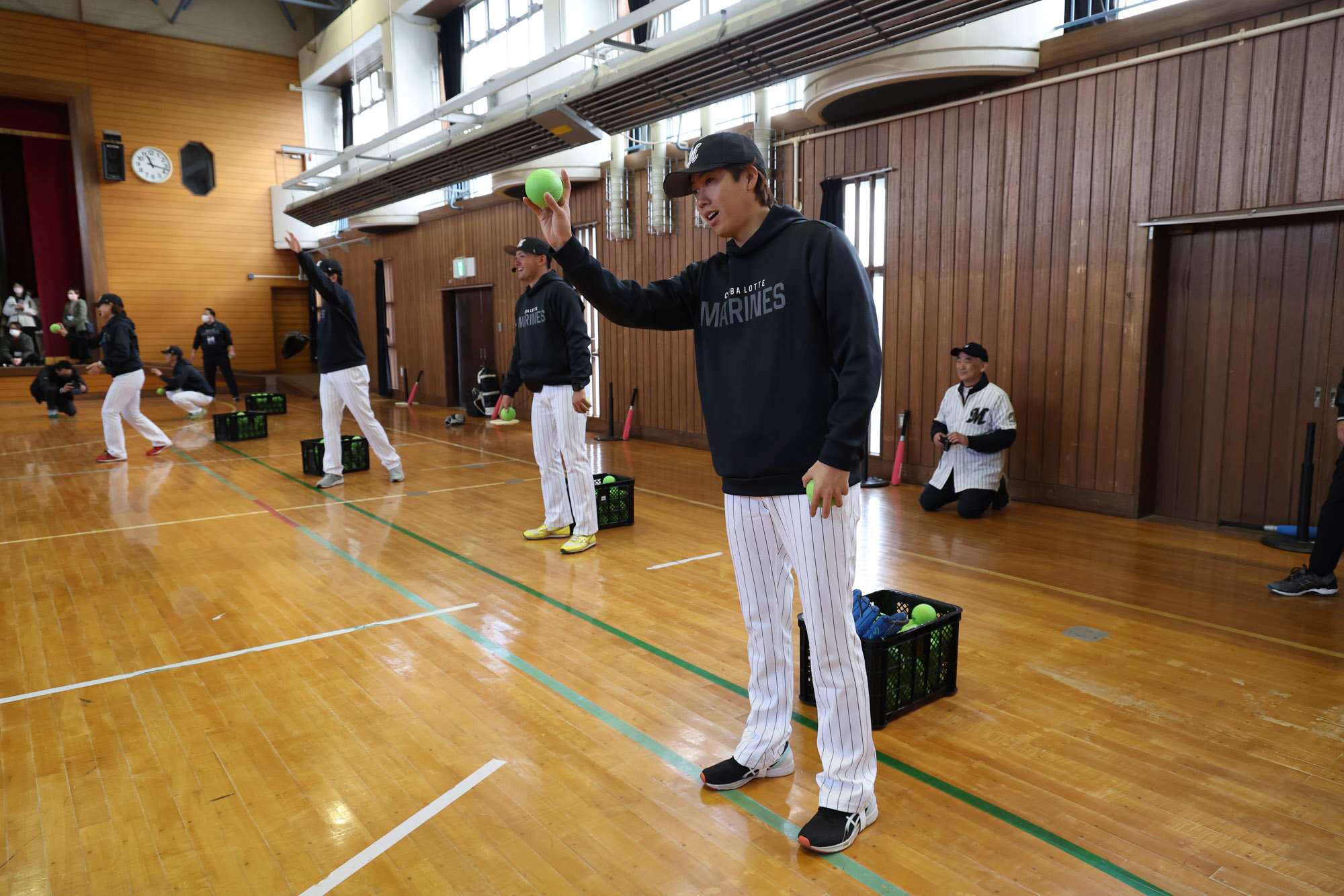 八日市場特別支援学校の体育館でのようす。マリーンズの選手たちがボールを持って丁寧に教えている