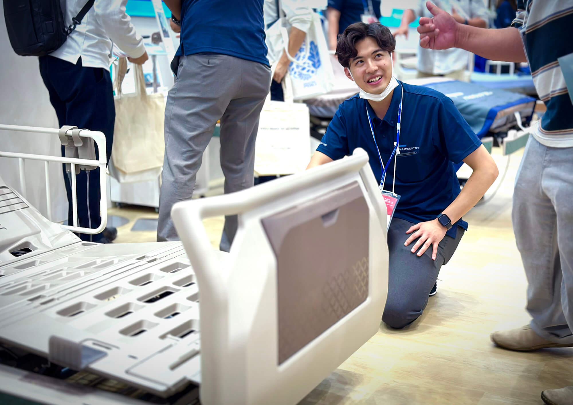 来場者に新製品の説明を笑顔で行うパラマウントベッドのスタッフ