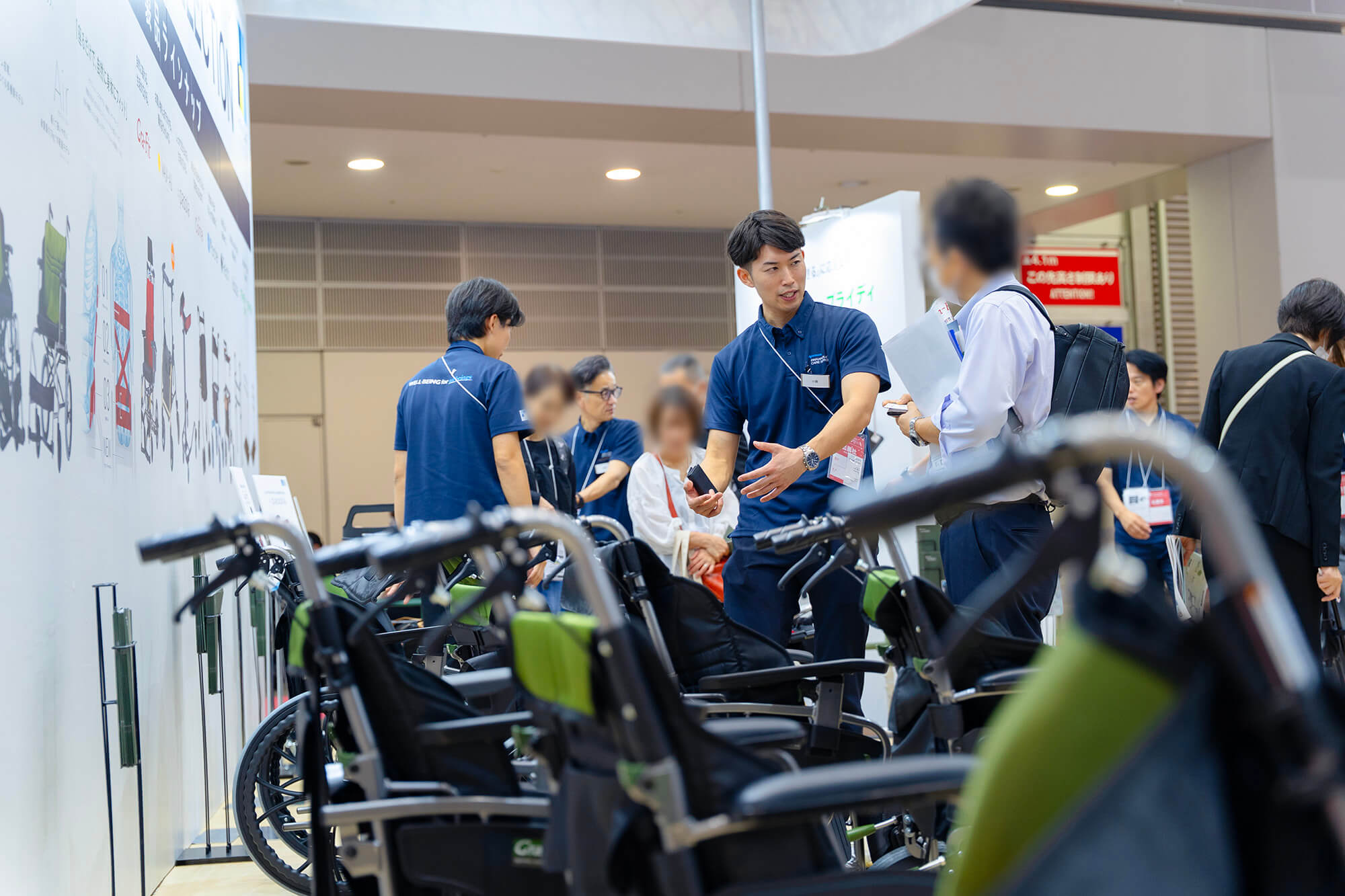 来場者に車いす「Gra-Fit（グラフィット）」の説明をするパラマウントケアサービススタッフ