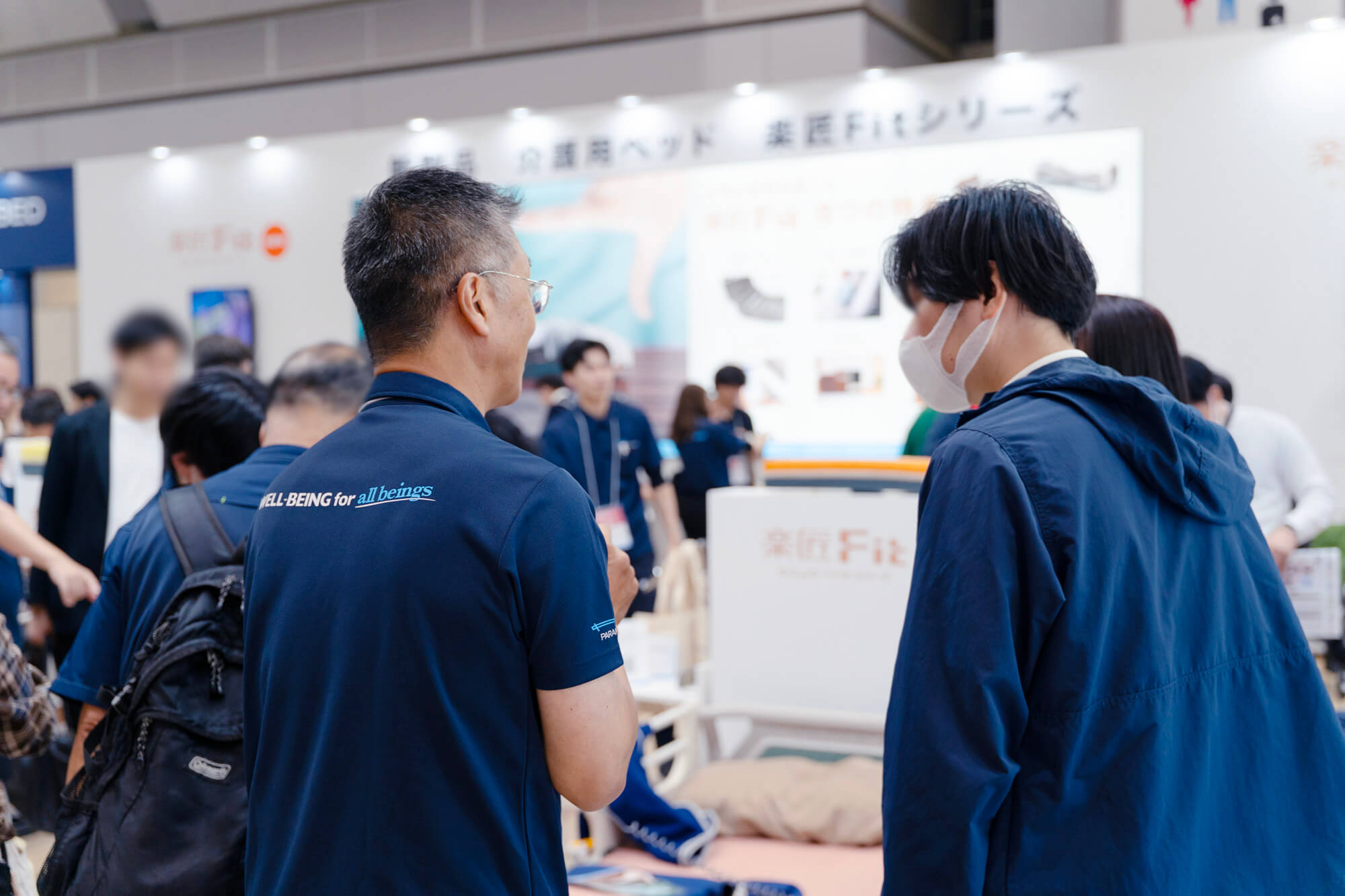 「H.C.R.2025 第52回国際福祉機器展&フォーラム」パラマウントベッドブースで来場者に説明をするスタッフ