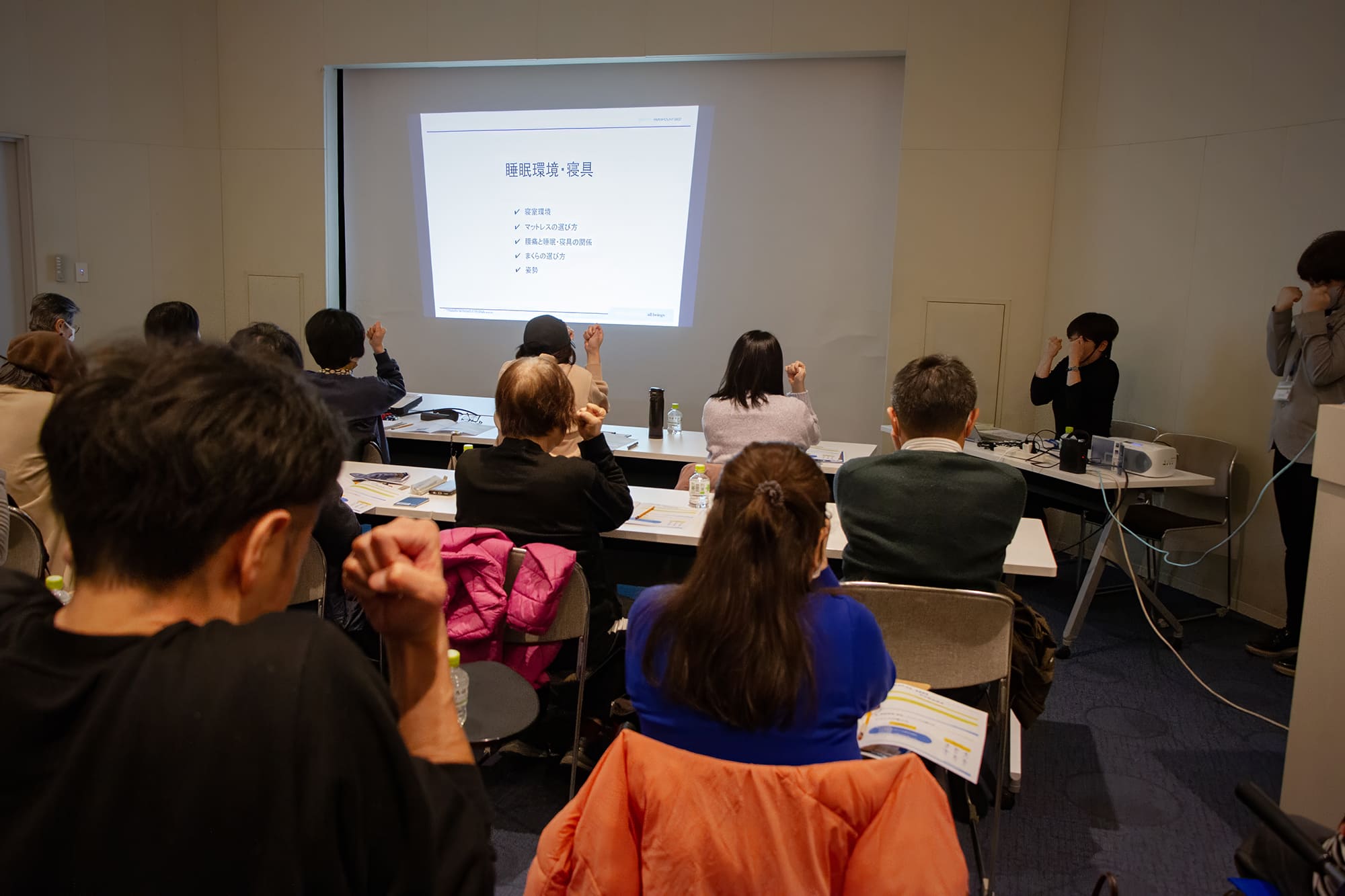 リラックス体操。登壇者と参加者全員で拳をぎゅーっと握りしめている