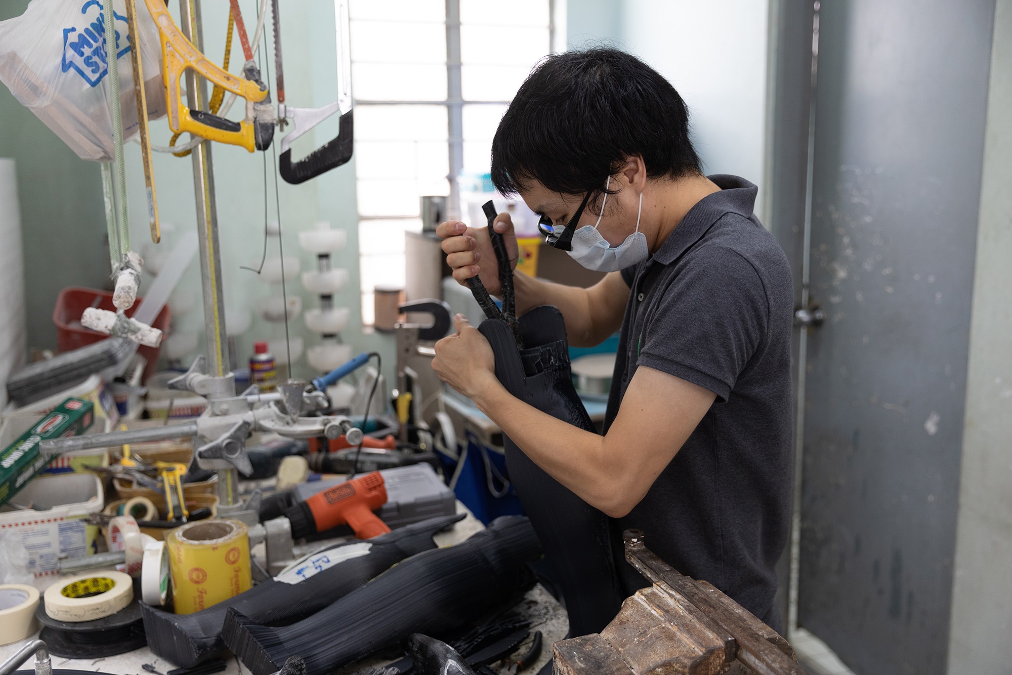 工具を手に3Dプリントした義足の調整をする小林義明義肢装具士