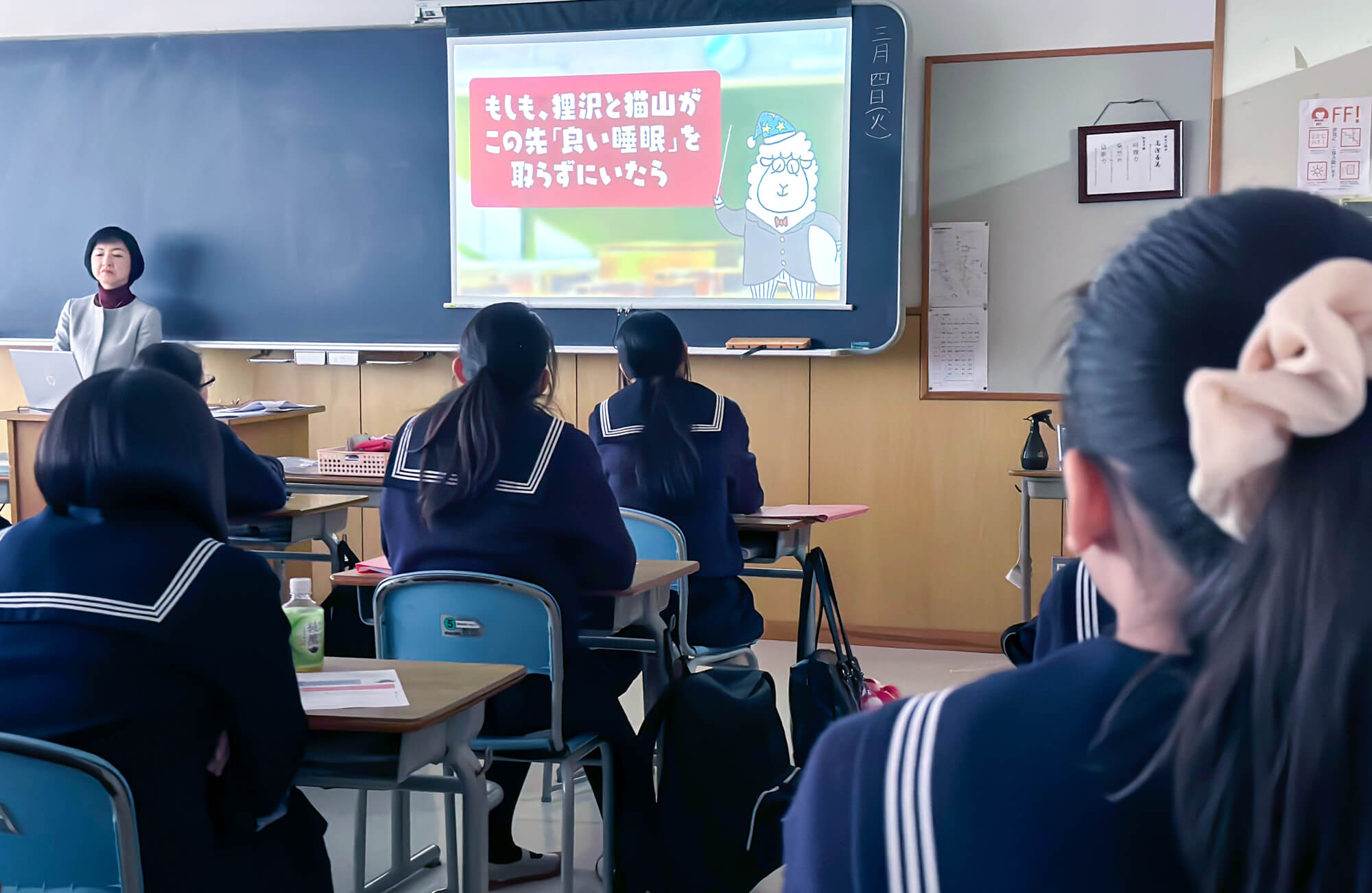 全員で動画をみているシーン。動画では「良い睡眠」の解説が流れている
