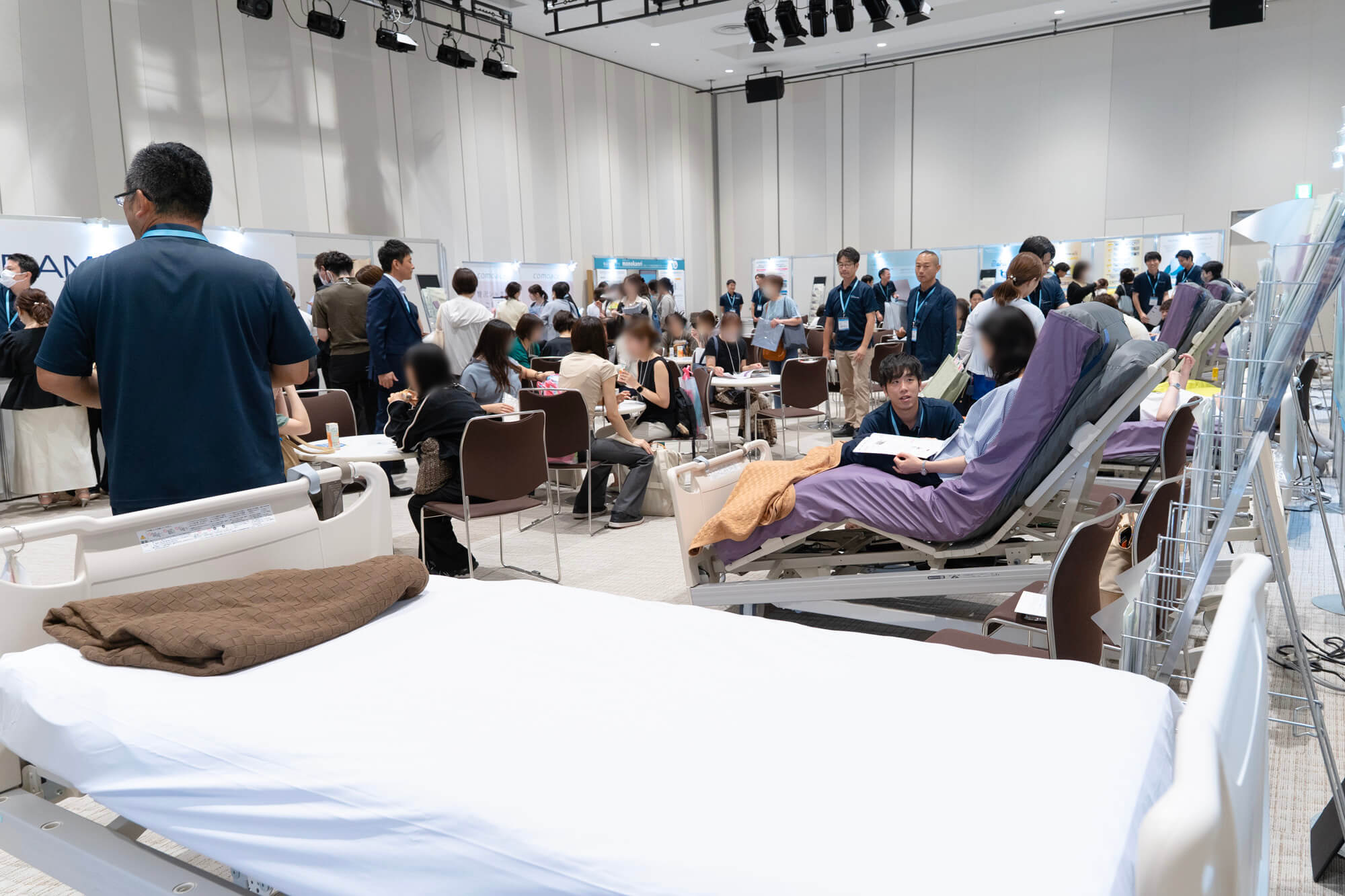 パラマウントベッドが出展したホスピタリティルーム。大勢の来場者が製品の説明を受けている