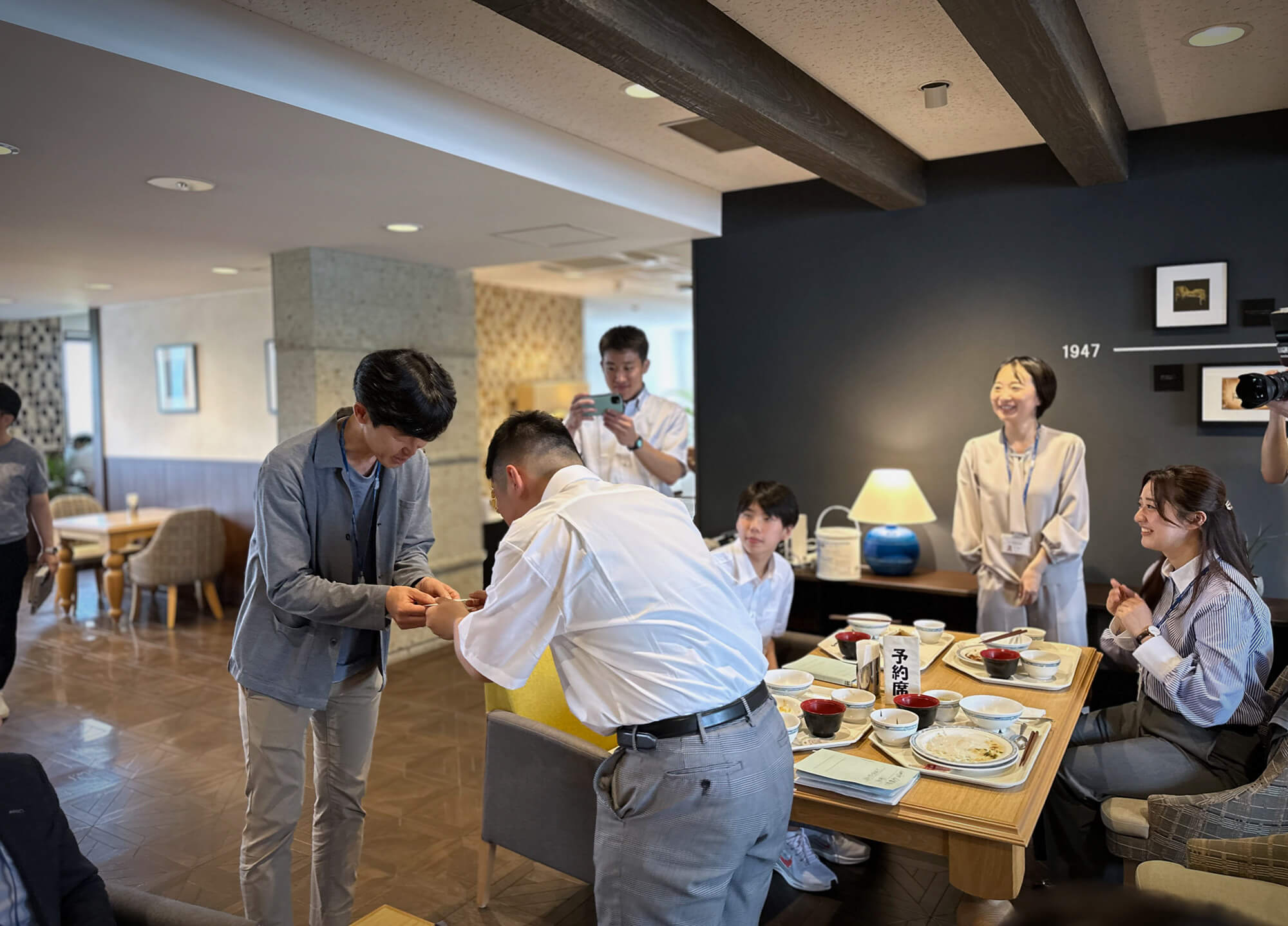 生徒が社員と名刺交換。通りかかったパラマウントベッド睡眠研究所木暮所長と長橋中学校生徒