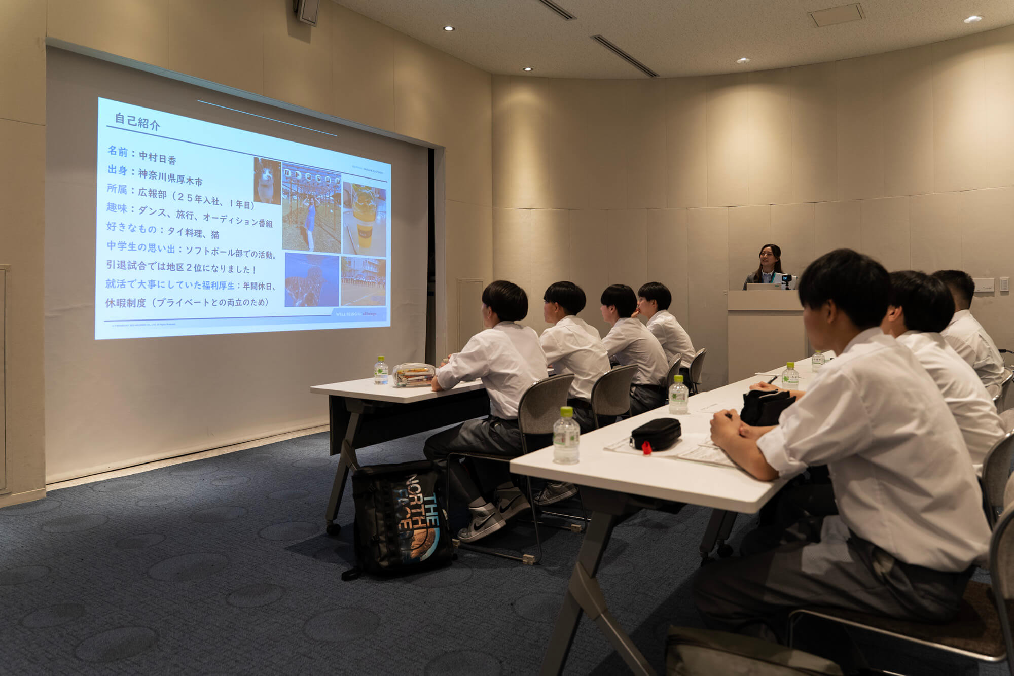 長橋中学の生徒たちにスライドを使って自己紹介をする広報部中村さん