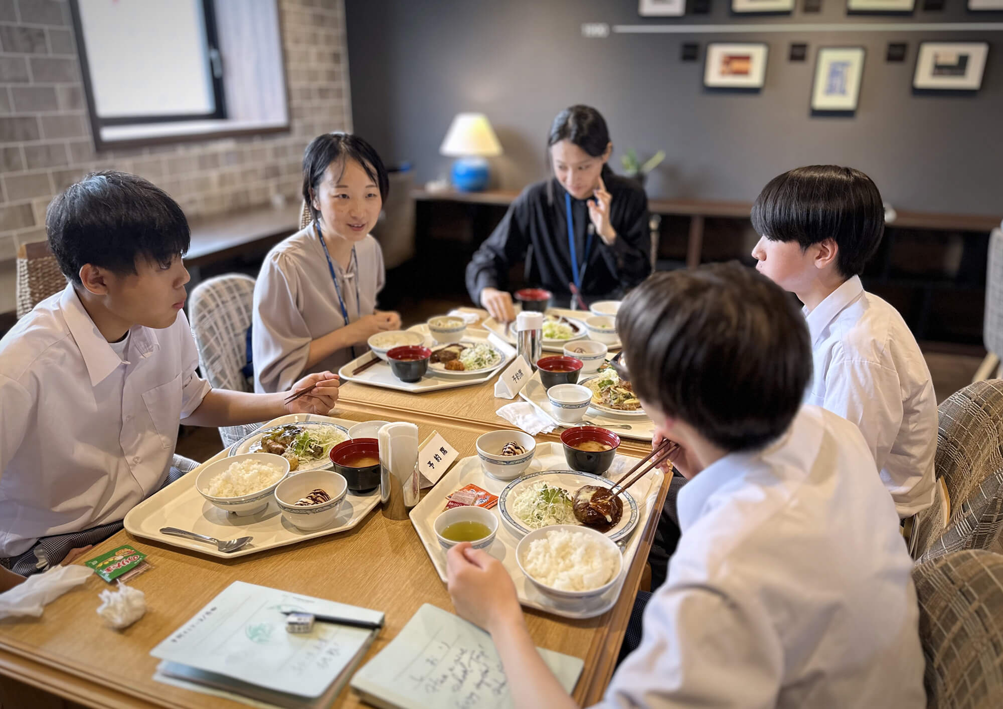 社員食堂で生徒と社員が一緒にランチを取っている