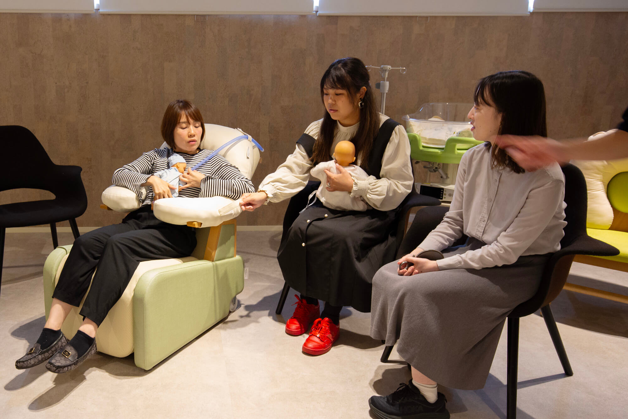 OyaCocoに座った様子と、機能を説明するTsubaki Projectメンバー